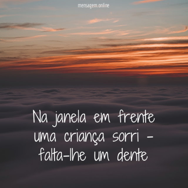 Na janela em frente uma criança sorri - falta-lhe um dente